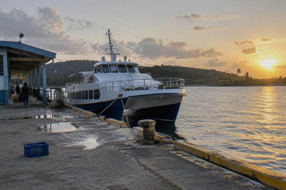 A passenger ferry docked at a small island terminal in late afternoon light