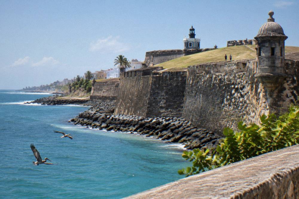 Historic stone fortress wall along the waterfront in Old San Juan under a clear sky
