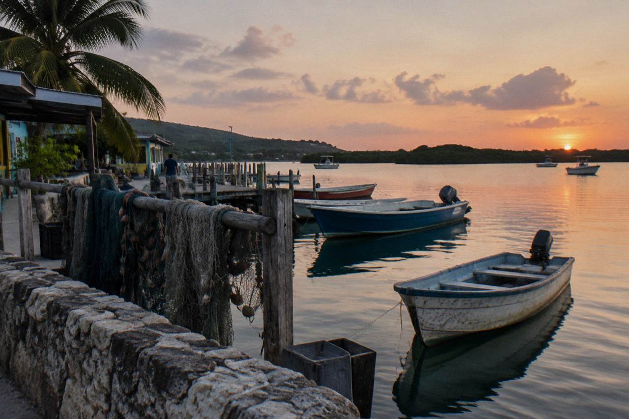 Wooden boats moored on calm water at dusk in a south coast fishing village