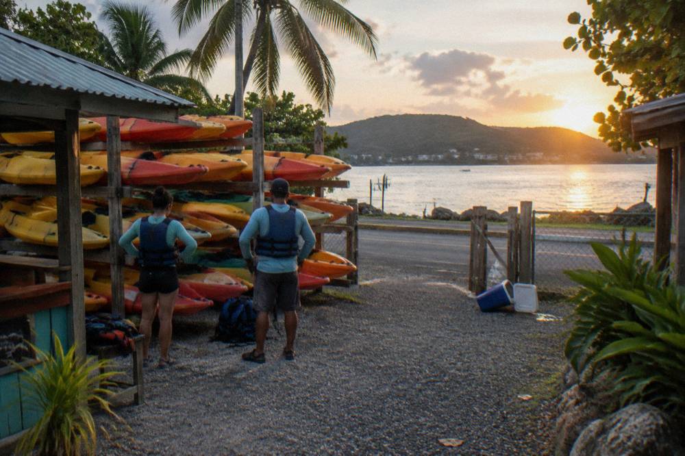 Waterfront meeting area at Las Croabas with kayaks stacked before a night tour