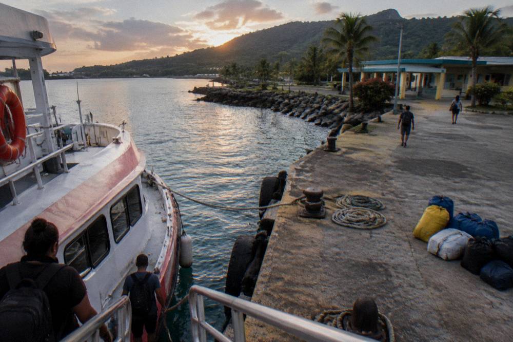 A small passenger ferry at a Caribbean dock in late afternoon light