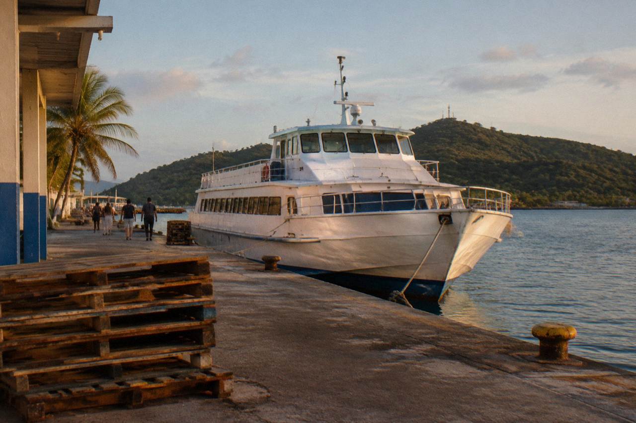 A passenger ferry at a Caribbean coastal terminal in late afternoon light